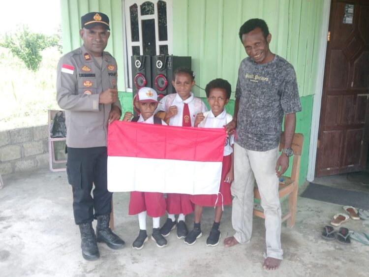 Sambut HUT Ke-81 Kemerdekaan RI, Kapolsek Senggi Bagikan Bendera Merah Putih kepada Warga